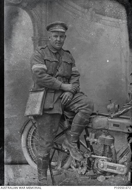 Portrait of an unidentified 2nd Division Signaller with a despatch motorcycle. 