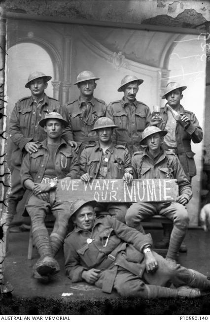 Group portrait of eight unidentified members of the 2nd Division. Several of the soldiers wear identity bracelets in the shape of Australia. 