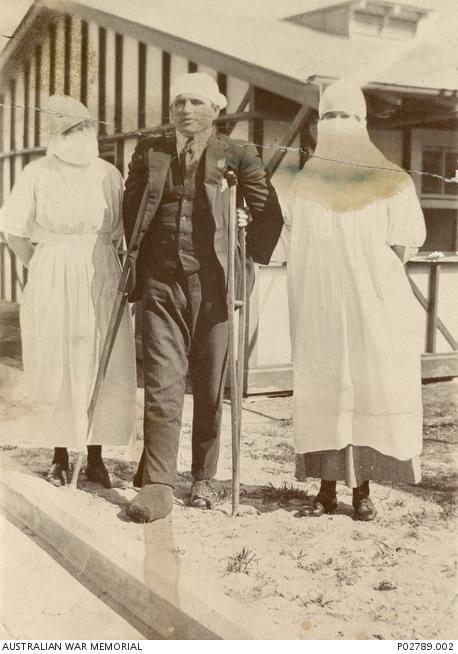 Voluntary Aid Detachment nurses M.M. Brooks and “Smithy” with a recovering soldier outside the flu ward at the Randwick Military Hospital, 1919.