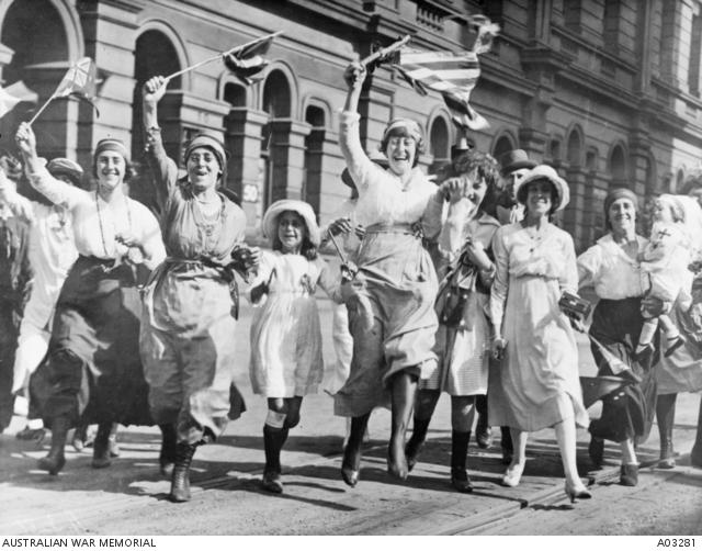 A group of women and children rejoicing in a street in Sydney at the signing of the Armistice.