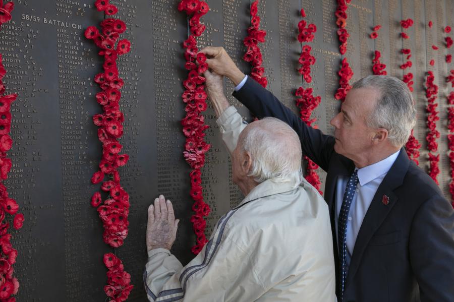 Gordon Willoughby placing a poppy on the Roll of Honour