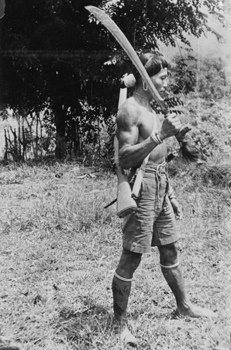 Iban armed with rifle and parang