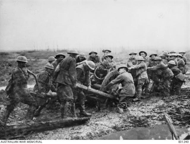 Soldiers moving a gun through the mud