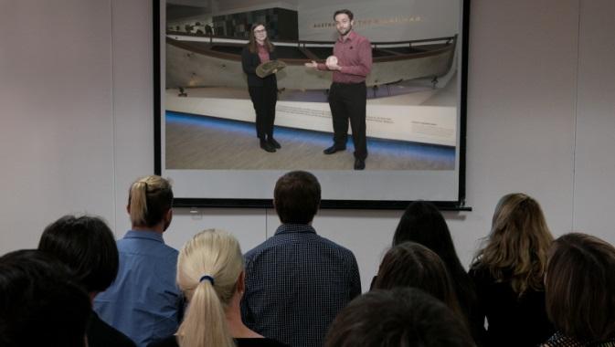 An audience watches a virtual excursion from a classroom