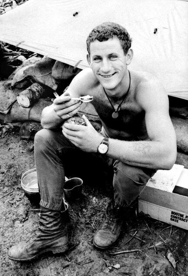 Bombardier Dick King eating tinned pecan pie with his coffee, in Phuoc Tuy Province, 1967.